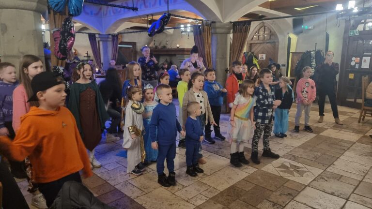 grupa dzieci stojąca w restauracji i patrząca na pokaz